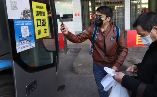 2月19日，在四川省仁寿县联营汽车客运站，外出务工人员登车前进行扫码登记